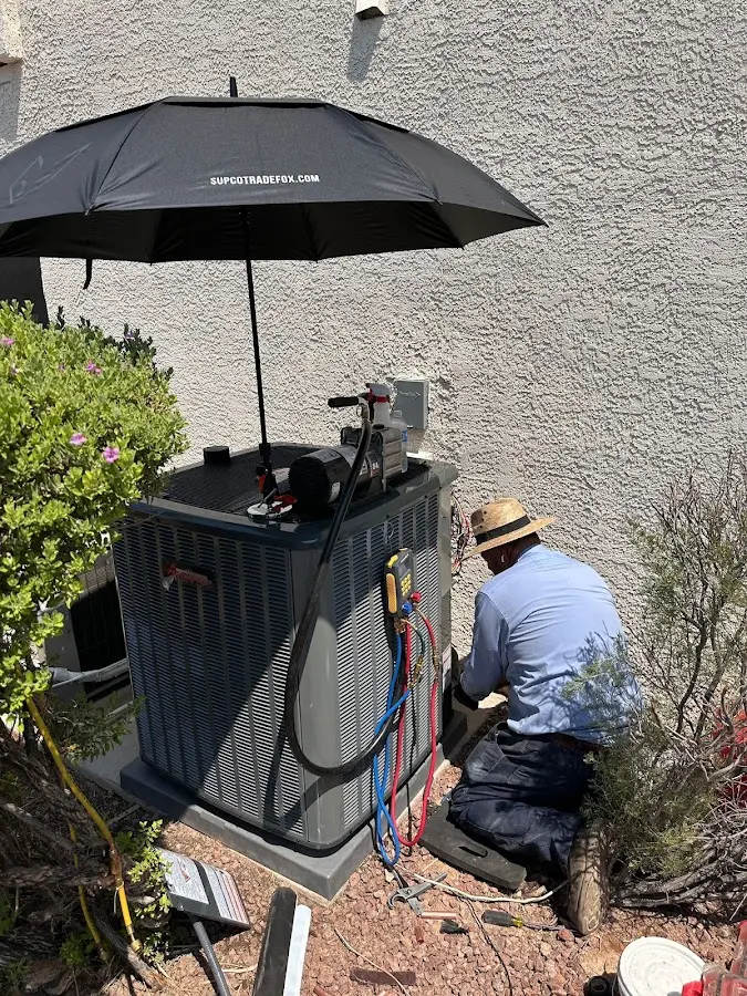 HVAC technician performing outdoor AC maintenance in Haddon