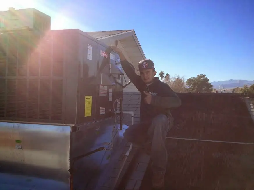 HVAC technician performing AC Tune-Up on a rooftop unit in Haddon